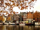 Amsterdam, cladiri colorate separate de numeroase canale. Acele vaporase vechi de pe marginea canalului sunt de fapt locuinte