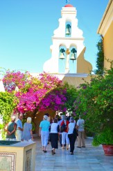 o intrare cu o frumoasa arcada impodobita cu verdeata si flori multicolor ce iti incanta privirea